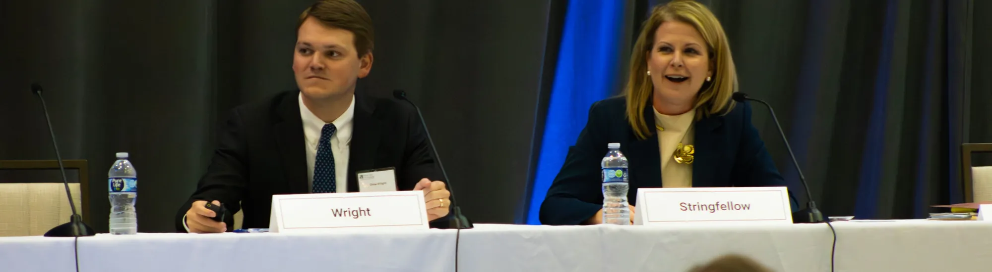 Two people sitting at a panel table labeled "State of Georgia."